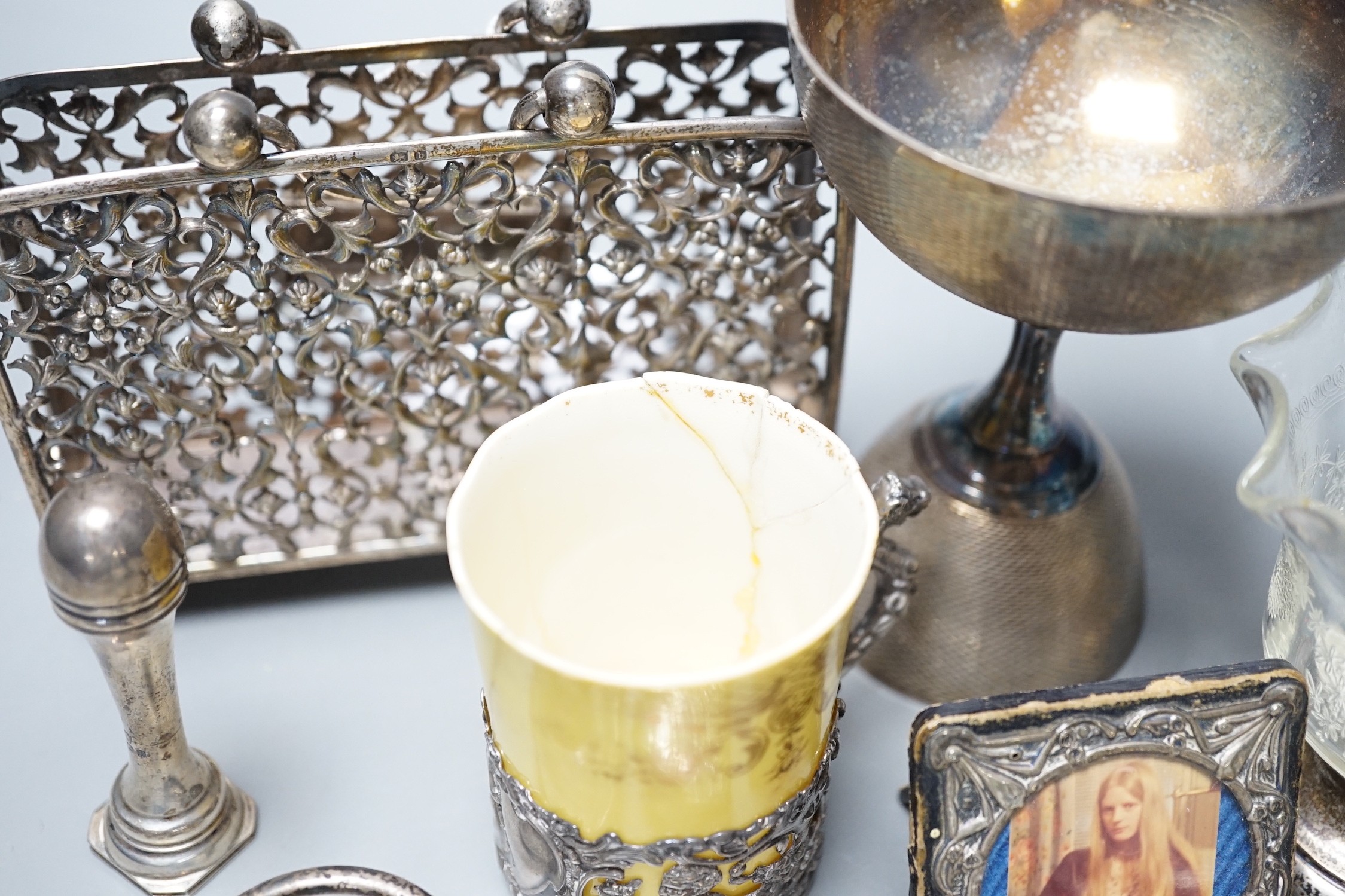A small group of collectable items including a silver stationary rack, Laurence Emanuel, Birmingham, 1901, height 9.7cm, a silver communion goblet, silver mounted porcelain coffee cup, silver mounted glass vase, silver v
